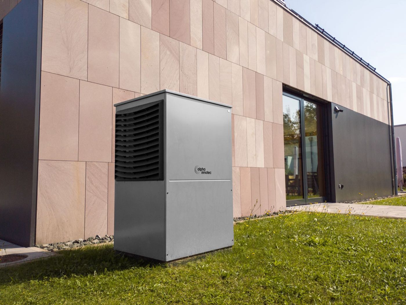 Thermopompe murale installée devant une résidence moderne — remplacement complet du chauffage au mazout